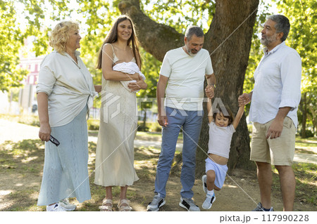Happy multi-generation family walking together in the park 117990228