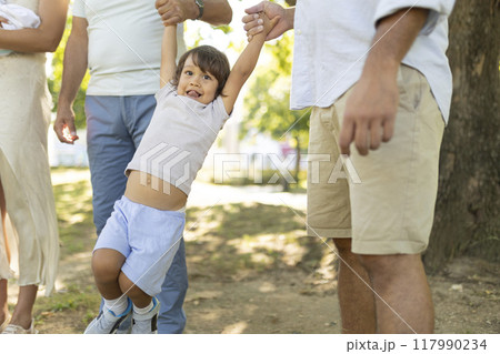Happy family walking together in the park on a sunny day Happy family walking together in the park on a sunny day 117990234