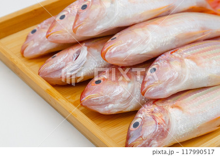 木製のトレーに並べられたカラフルな魚いとより 117990517