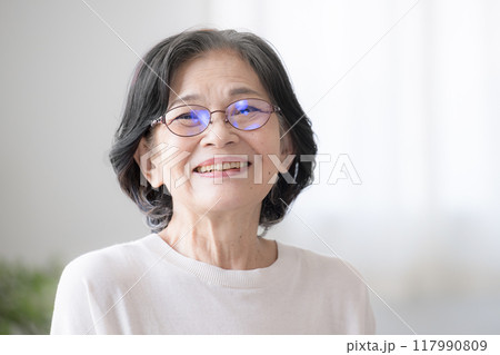 笑顔のシニア女性　部屋の中で大笑いする健康的な高齢者女性のクローズアップ　カメラ目線 117990809