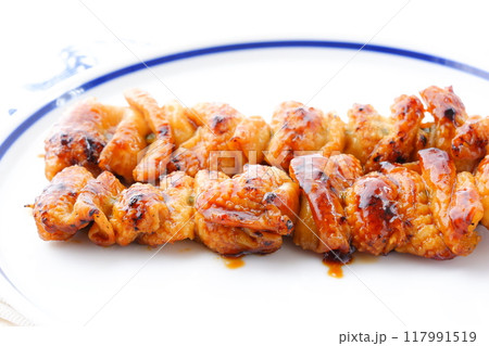 炭火焼にした焼き鳥をタレで食べる（とり皮） 117991519