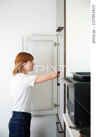 食器棚を開ける女性　家事　料理　生活 117991625
