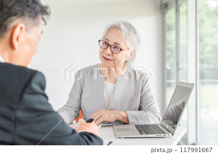 打ち合わせ・ミーティング・会議をするシニア世代のビジネスウーマンとビジネスマン 117991667
