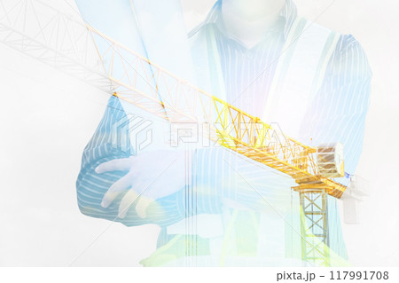 Double exposure image of professional engineer in protective helmet and blueprints paper at building construction site 117991708