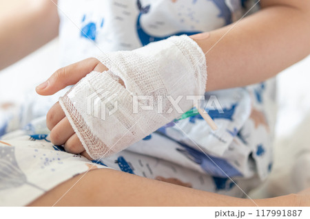 Close up child hand with saline IV solution in hospital 117991887