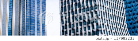 Skyscraper glass building of corporate headquarters in the downtown business area. Towering facade and windows embodying sleek, modern office environment. Financial institution. Modern architecture. 117992233
