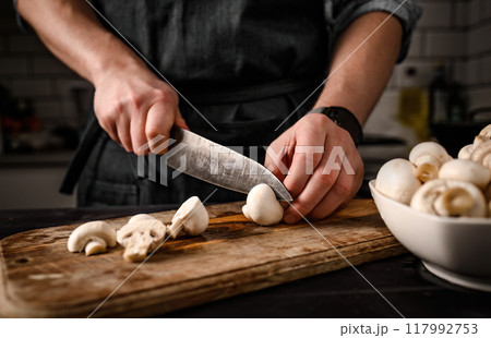 Chief hands cutting shampignons with knife 117992753