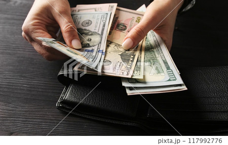 Woman Counting Her Cash Savings In Usa Dollar Bills Woman Counting Her Cash Savings In Usa Dollar Bills 117992776