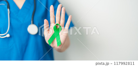 Doctor with green Ribbon for world Lymphoma Awareness September month, world Mental Health Day, Liver, Gallbladders, bile duct, cervical, kidney Cancer. Healthcare and world cancer day concept Doctor with green Ribbon for world Lymphoma Awareness September month, world Mental Health Day, Liver, Gallbladders, bile duct, cervical, kidney Cancer. Healthcare and world cancer day concept 117992811