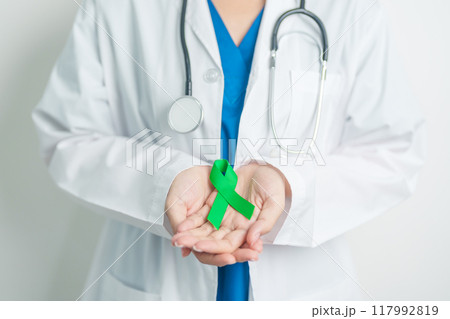Doctor with green Ribbon for world Lymphoma Awareness September month, world Mental Health Day, Liver, Gallbladders, bile duct, cervical, kidney Cancer. Healthcare and world cancer day concept Doctor with green Ribbon for world Lymphoma Awareness September month, world Mental Health Day, Liver, Gallbladders, bile duct, cervical, kidney Cancer. Healthcare and world cancer day concept 117992819