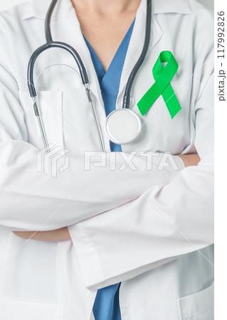 Doctor with green Ribbon for world Lymphoma Awareness September month, world Mental Health Day, Liver, Gallbladders, bile duct, cervical, kidney Cancer. Healthcare and world cancer day concept 117992826