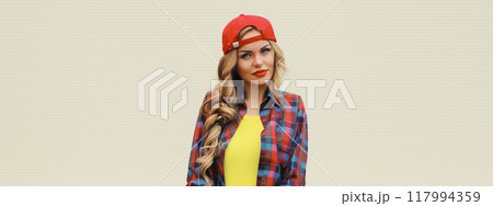 Stylish young blonde woman posing with skateboard on city street 117994359