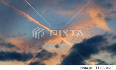 夕焼け空に伸びる飛行機雲の風景 117995081