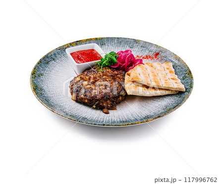 Juicy grilled cutlet served with pita bread and tomato sauce on plate Juicy grilled cutlet served with pita bread and tomato sauce on plate 117996762