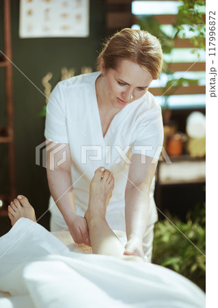medical massage therapist in spa salon massaging clients leg 117996872