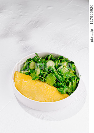 Delicious omelette with fresh green salad for healthy breakfast 117996926