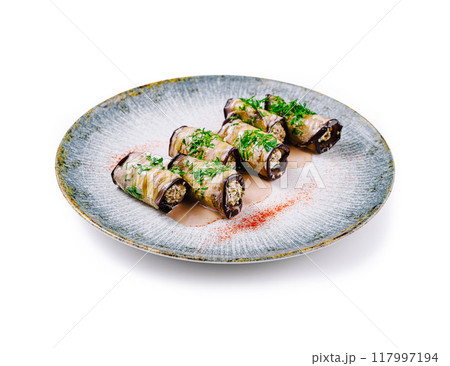 Delicious eggplant rolls stuffed with nuts and herbs lying on plate 117997194