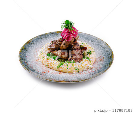 Grilled beef tenderloin with polenta, pickled onions and parsley pesto on modern plate Grilled beef tenderloin with polenta, pickled onions and parsley pesto on modern plate 117997195