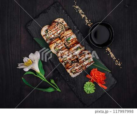 Sushi rolls with eel and cucumber lying on black stone tray 117997998