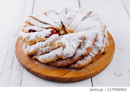 Delicious homemade cherry pie sprinkled with powdered sugar on white rustic table 117998062