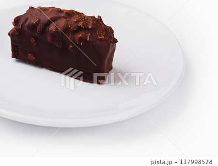 Chocolate covered nutty bar on white plate 117998528