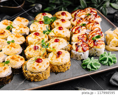 Delicious assorted sushi platter on dark stone background Delicious assorted sushi platter on dark stone background 117998595