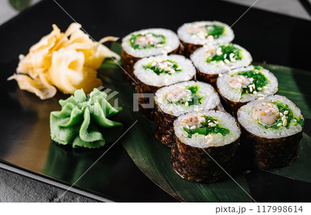 Elegant sushi roll display on black plate Elegant sushi roll display on black plate 117998614