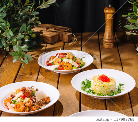 Gourmet dishes on rustic wooden table 117998769