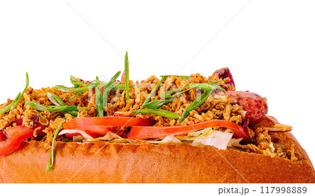 Delicious gourmet hot dog with toppings on white Delicious gourmet hot dog with toppings on white 117998889