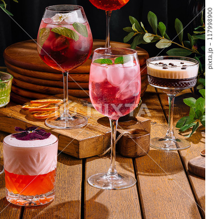Assortment of colorful cocktails on rustic wooden surface Assortment of colorful cocktails on rustic wooden surface 117998900