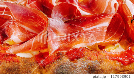 Delicious prosciutto topped pizza close up 117998901