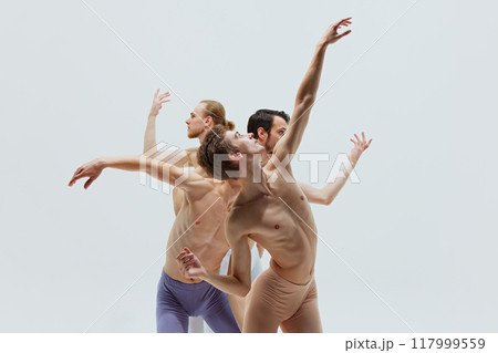 Trio of dancers expresses emotion and storytelling through their synchronized and flowing movements against white studio background. Trio of dancers expresses emotion and storytelling through their synchronized and flowing movements against white studio background. 117999559