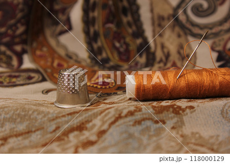Brown Thread With Thimble and Scissors on Vintage Fabric 118000129
