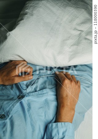 man in bed handles his urinary catheterization 118000390