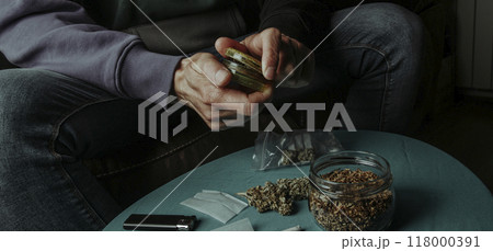 shreds a cannabis bud with a grinder, banner format shreds a cannabis bud with a grinder, banner format 118000391