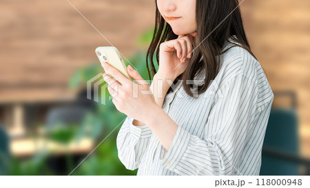 スマホを見て考える女性・ビジネスウーマン スマホを見て考える女性・ビジネスウーマン 118000948