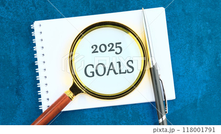 New Year New Start, Resolutions, Strategy, mission concept. 2025 GOALS through a magnifying glass on a blank sheet of notepad 118001791