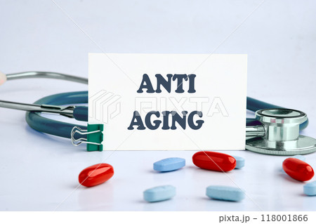 Words ANTI AGING on a white business card on a light background Words ANTI AGING on a white business card on a light background 118001866