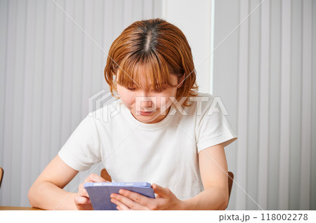 家でタブレットを操作する女性 118002278
