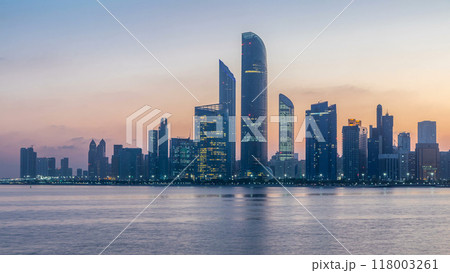 Abu Dhabi city skyline with skyscrapers before sunrise with water reflection night to day timelapse Abu Dhabi city skyline with skyscrapers before sunrise with water reflection night to day timelapse 118003261