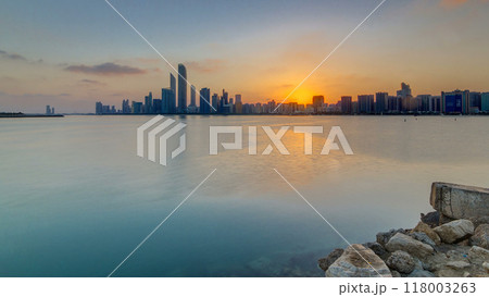 Abu Dhabi city skyline on sunrise time with water reflection timelapse. Abu Dhabi city skyline on sunrise time with water reflection timelapse. 118003263