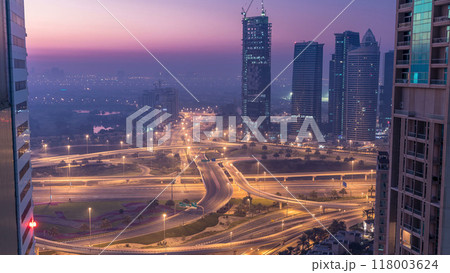 Aerial view of a road intersection in a big city night to day timelapse. Aerial view of a road intersection in a big city night to day timelapse. 118003624