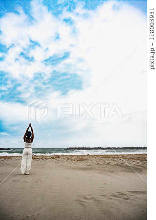 砂浜で立ちヨガをする若い女性 砂浜で立ちヨガをする若い女性 118003931