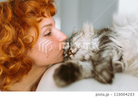 portrait red-haired teenage girl with gray fluffy cat 118004283