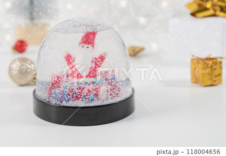 Snow globe with Santa Claus and gift boxes. Selective focus and Bokeh lights. Winter composition 118004656