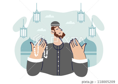 Islamic man praying doing hajj in holy month of ramadan or eid al-fitr, stands near mosques 118005209