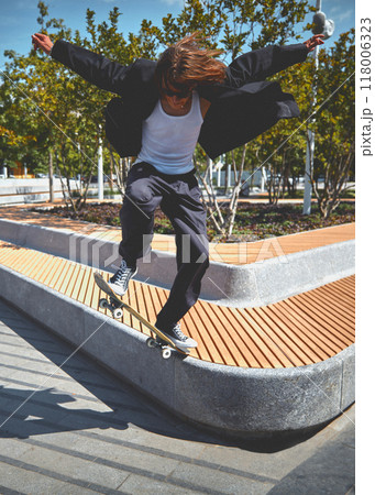 Dynamic image of young stylish guy in motion, showing skill, doing trick while skateboarding in empty public park in the morning Dynamic image of young stylish guy in motion, showing skill, doing trick while skateboarding in empty public park in the morning 118006323