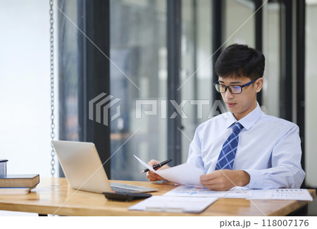 Businessman Analyzing Risk, Investment, and Market Data in the Office Businessman Analyzing Risk, Investment, and Market Data in the Office 118007176