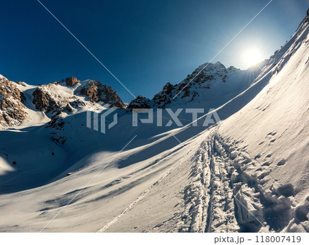 Winter Mountain Beauty: Breathtaking Alpine Scenery Above Cloud Level Along a High-altitude Trekking Route in Almaty Region, Kazakhstan's National Park. Winter Mountain Beauty: Breathtaking Alpine Scenery Above Cloud Level Along a High-altitude Trekking Route in Almaty Region, Kazakhstan's National Park. 118007419