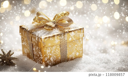 golden gift box with a glittering bow, surrounded by snow and shimmering lights 118009857